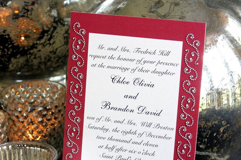 Ornate swirls of photo illustrated pearls decorate this red invitation. It is definitely for an eye catching affair. It is available in several other colors, and is part of a full wedding collection.