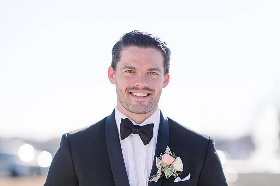 Groom in tux holding bouquet
