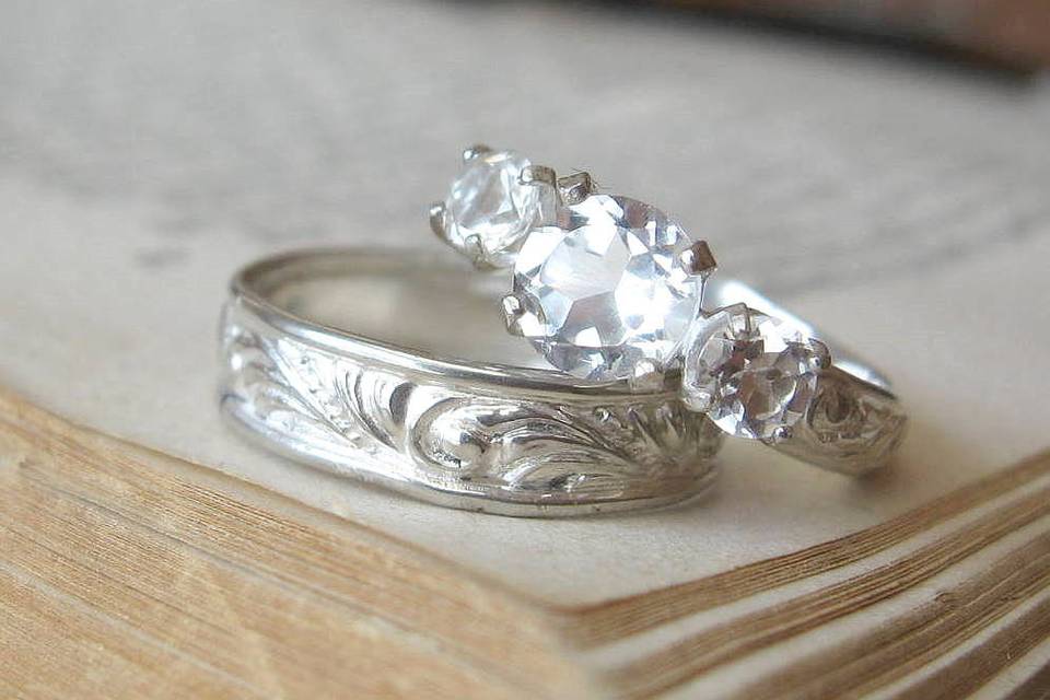 Unique and affordable customizable wedding sets
Three stone engagement ring in sterling with white topaz
Swirl band with thin rolled edge in sterling silver