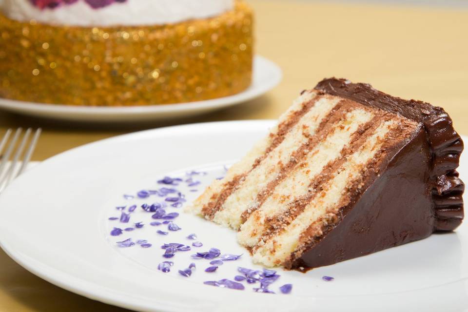 A slice of our delicious vanilla cake with chocolate ganache frosting.
