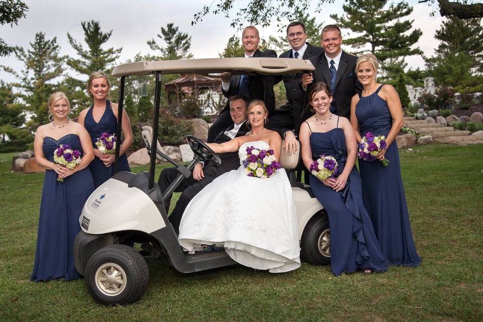 Bridal party posed on golf cart at country club wedding