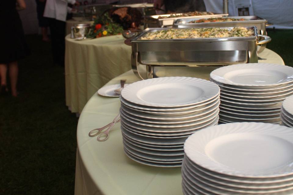 Buffet set up using serpentine tables with maize sparkle organza linens over lemon yellow linens.