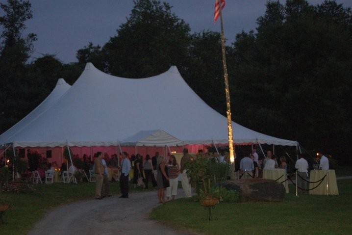 60' x 70' century pole tent with 9' x 10' entry tent with lighting at dusk.