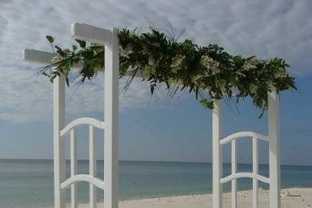 White arbor arch with unity sand table all with a view of the water