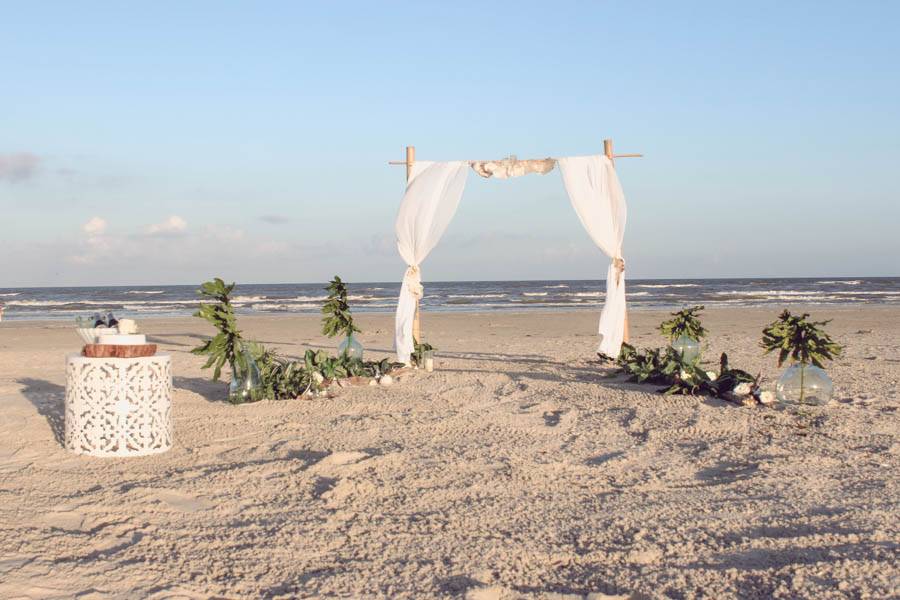 simple beach wedding with driftwood aisle and bamboo arch.