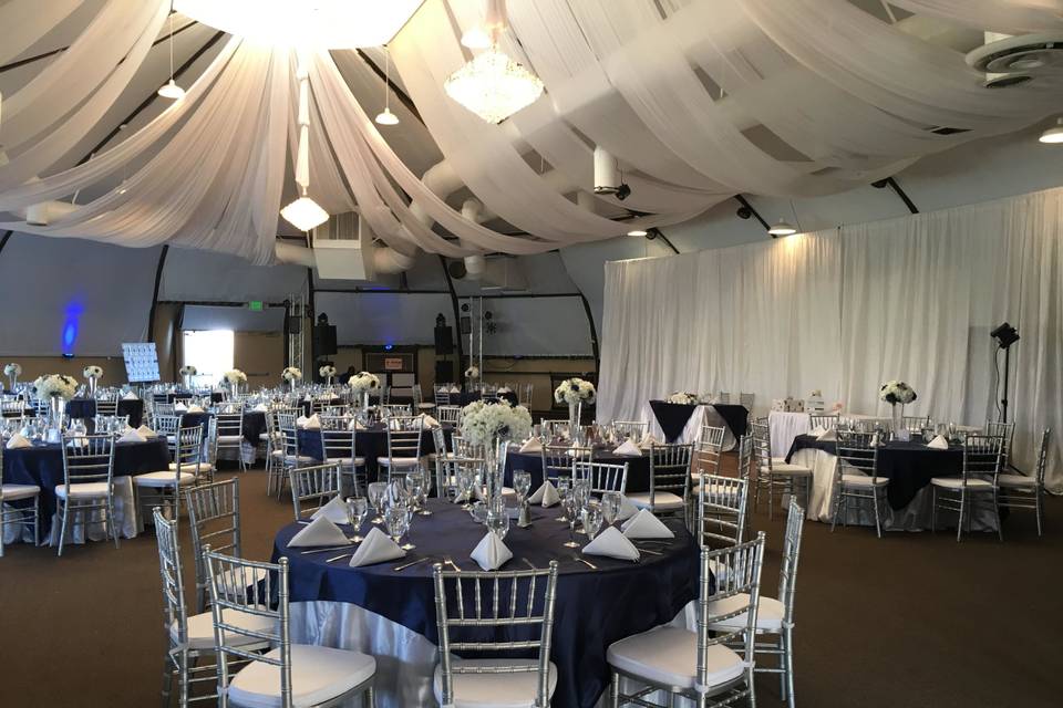 Navy blue overlays with satin white tablecloths