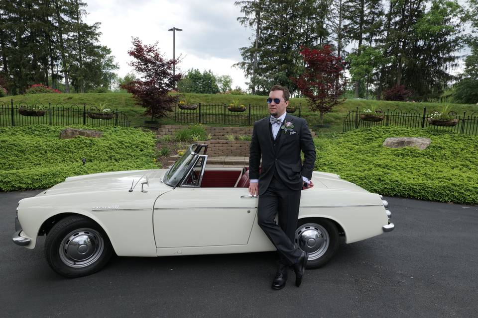 A cool groom with a cool car.