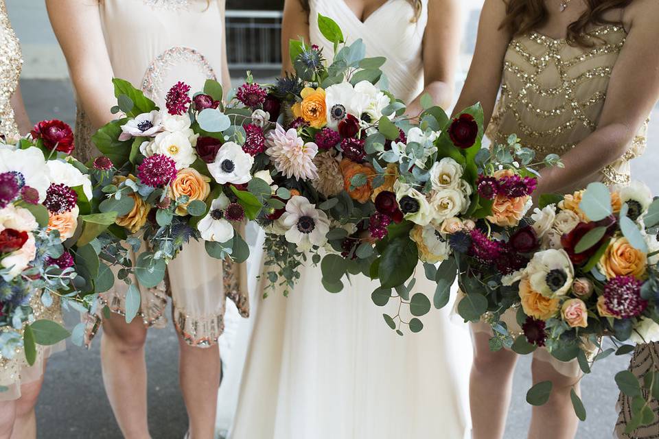 Garden Bouquets of blush and champagne with pops of cranberry and orange.