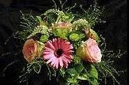 Pink and green wedding centerpiece of mums, roses, gerberas, and veronica.