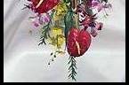 Tropical cascade-style bridal bouquet of faux anthurium, bird of paradise, heliconia, and several types of orchids.