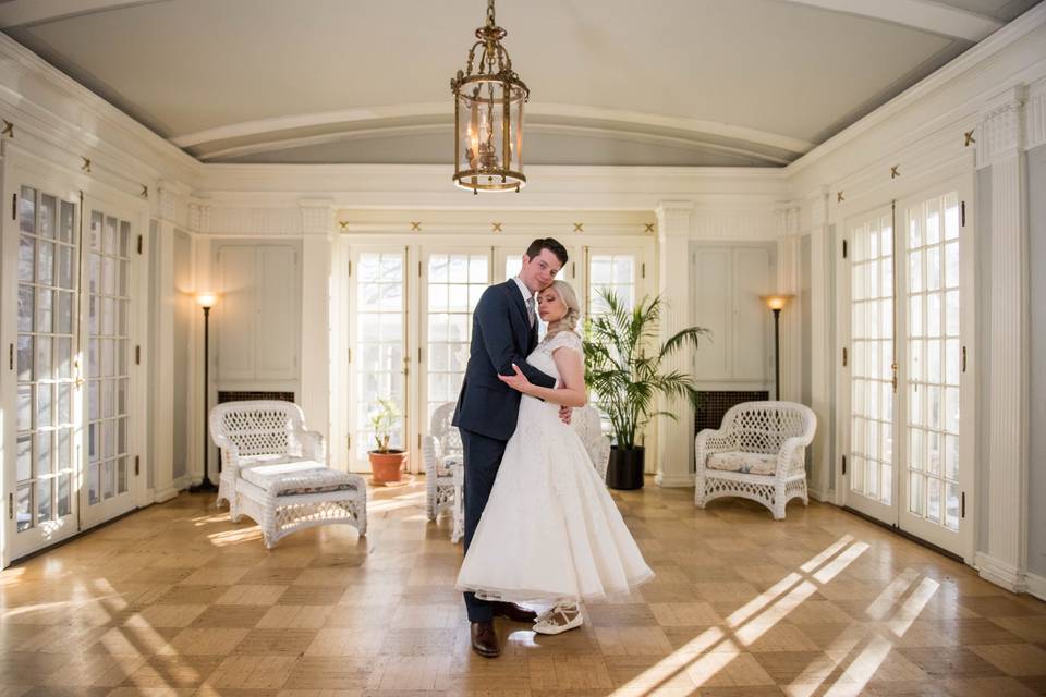 Newlyweds embracing under chandelier
