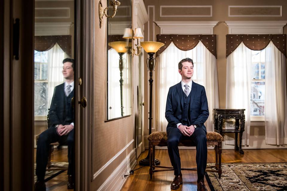 Groom posing in elegant room