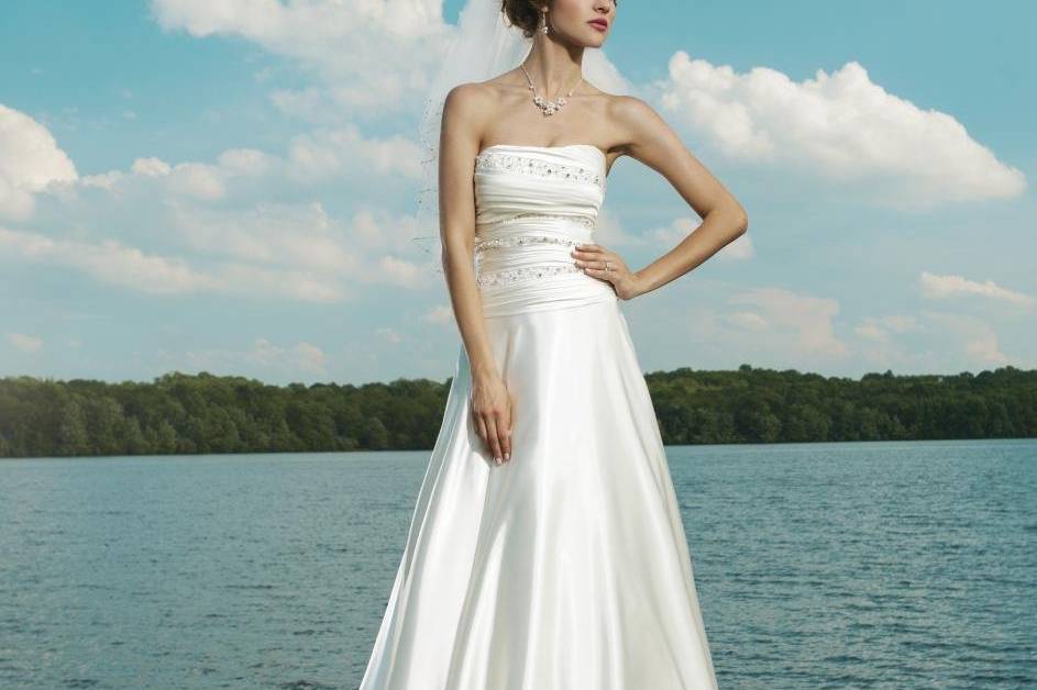 Style #3659
Strapless soft sweetheart ruched shimmer charmeuse with beading on the bodice and drop waist, circular cut skirt with buttons on back zipper into a chapel train.
