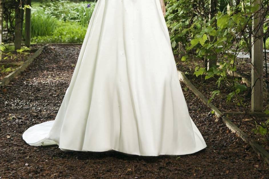 Style #3674
Strapless sweetheart with asymmetrical pleated taffeta bodice accented with beading Basque waist with full skirt, buttons up back zipper chapel train