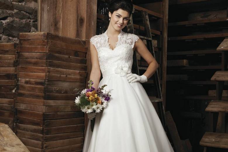 Style #3700
Cap lace V-neckline, satin bias band with a silk flower and beading accents natural waist, high illusion back neckline with buttons, circular cut organza tea length skirt. Available full length with chapel length train as 3701.