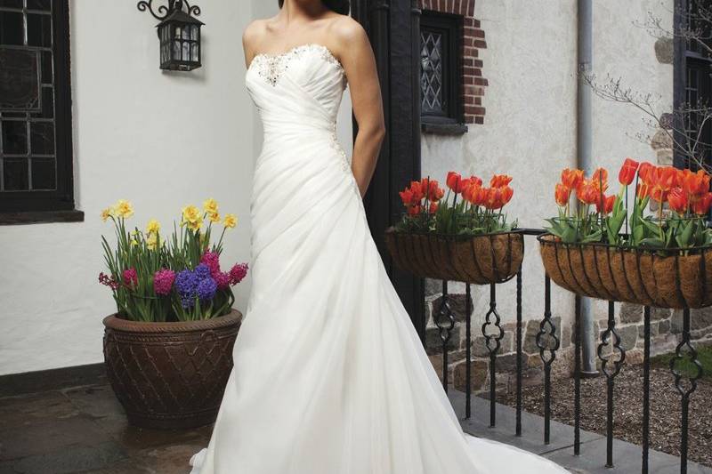 Style #3726
An asymmetric organza draped A-line gown with a beaded sweetheart neckline. This style has a lace up back and a chapel length train.