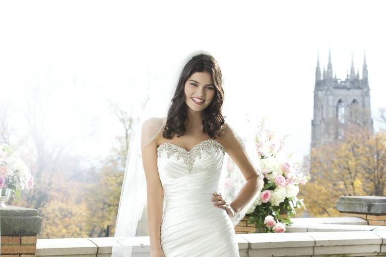 Preview 2014
Style 3757
This A-line gown has an asymmetrically draped charmeuse beaded sweetheart neckline. The gown ends with a chapel length train and features charmeuse buttons over the back zipper.