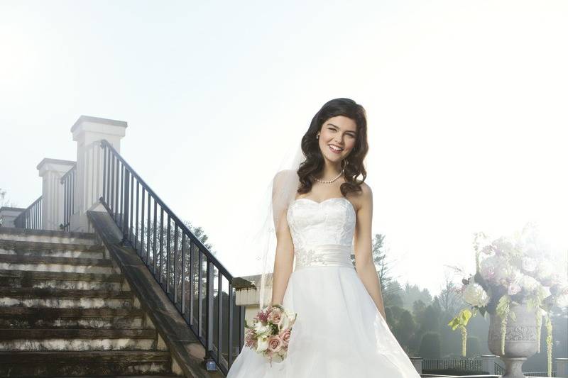 Preview 2014
Style 3754
This strapless satin embroidered bodice features a regal satin pleated cummerbund that is accented with a beaded motif on a full organza pick up ball gown. This gown has a chapel length train and satin buttons over the back zipper.