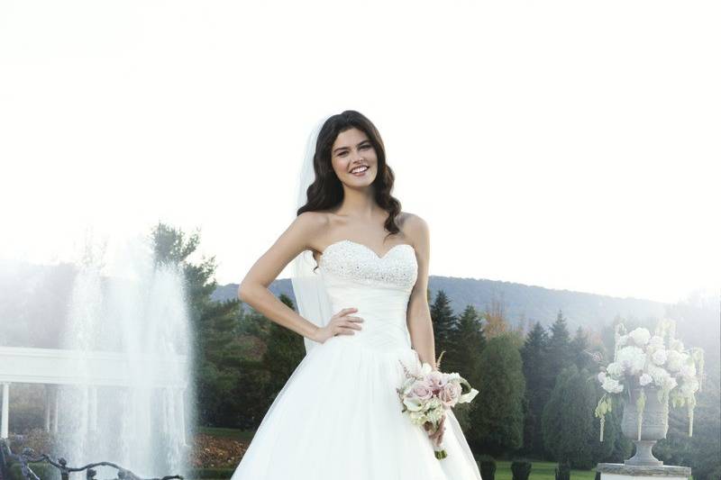 Preview 2014
Style 3752
Full tulle ball gown has a heavily beaded bustline on the tulle pleated basque waistline. There is scattered beading on the skirt that adds to the gown’s charm. The gown has a corset back and chapel length train.