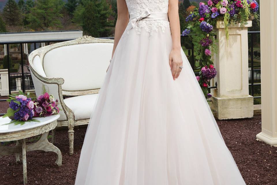 Style # 3816
Tulle and beaded Alencon lace ballgown with a sweetheart neckline. The gown is finished with a satin belt at the natural waist with a bow detail, satin covered buttons over the back zipper and a chapel length train.