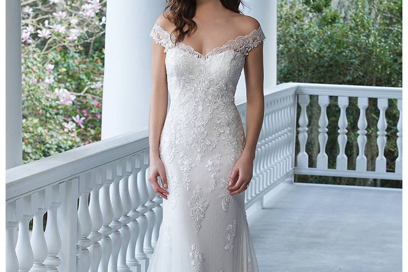 3938 <br> Show off your shoulders in this fit and flare tulle and point d'esprit gown with lace appliques, illusion back, and Jersey lining complete with a chapel length train.