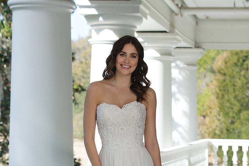 3947 <br> Beaded cotton embroidered lace, a soft English Net skirt, Jersey lining, and buttons to the end of the train adorn this slim A-line gown with a sweetheart neckline.