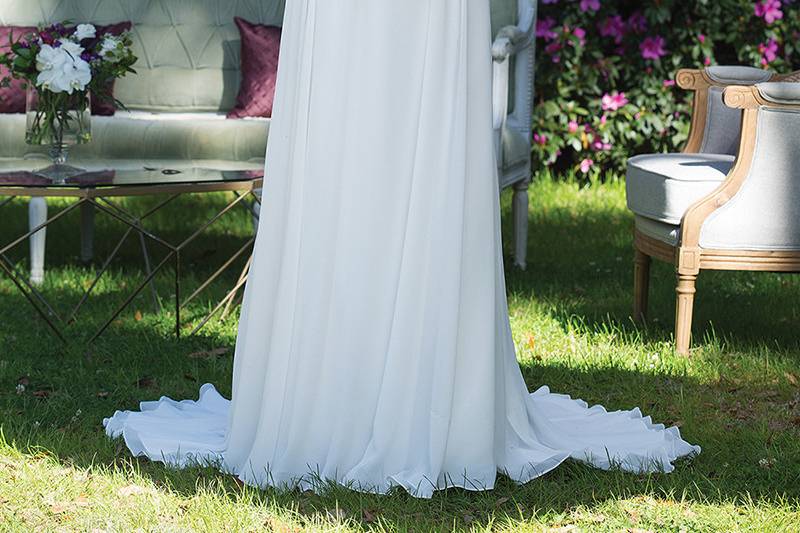 3951 <br> The soft fabrications of chiffon and tulle inspired the styling of this V-neck slim A-line gown which feature a beaded empire waist, illusion three quarter length sleeves, and chapel length train.