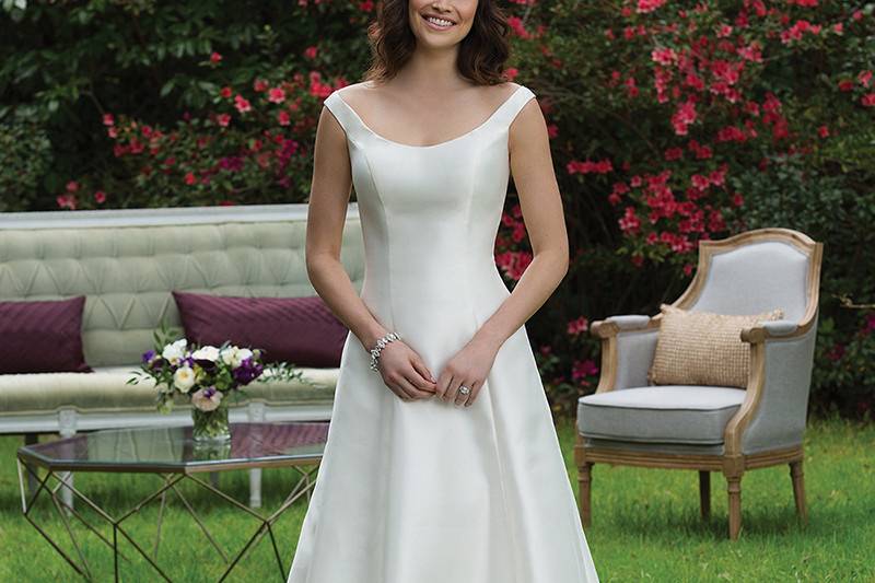 3959 <br> A sister to 3858, this Mikado gown features the same inverted pleats but with an A-line silhouette and portrait neckline. Buttons extend to the end of the train.