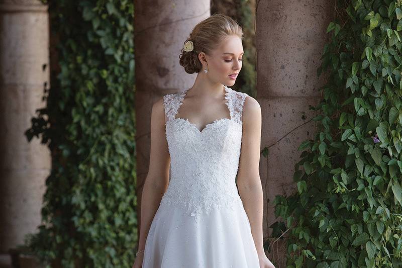 Sincerity Bridal	4009	<br>	Cinderella styling on this Queen Anne organza A-line. Embroidered lace accents the illusion straps and continues around to the illusion back. Light beading floats down the organza skirt finished with buttons at the zipper closure.