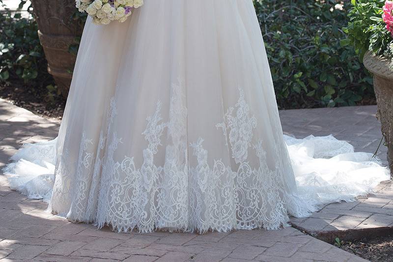 Sincerity Bridal	4025	<br>	Shine in this plunging V-neck with illusion sleeves. Hand placed Chantilly lace adorns the sleeves and bodice. At the hem of the gown Chantilly laces frames a finished scalloped look. Buttons complete the illusion back to the bottom of the zipper closure.