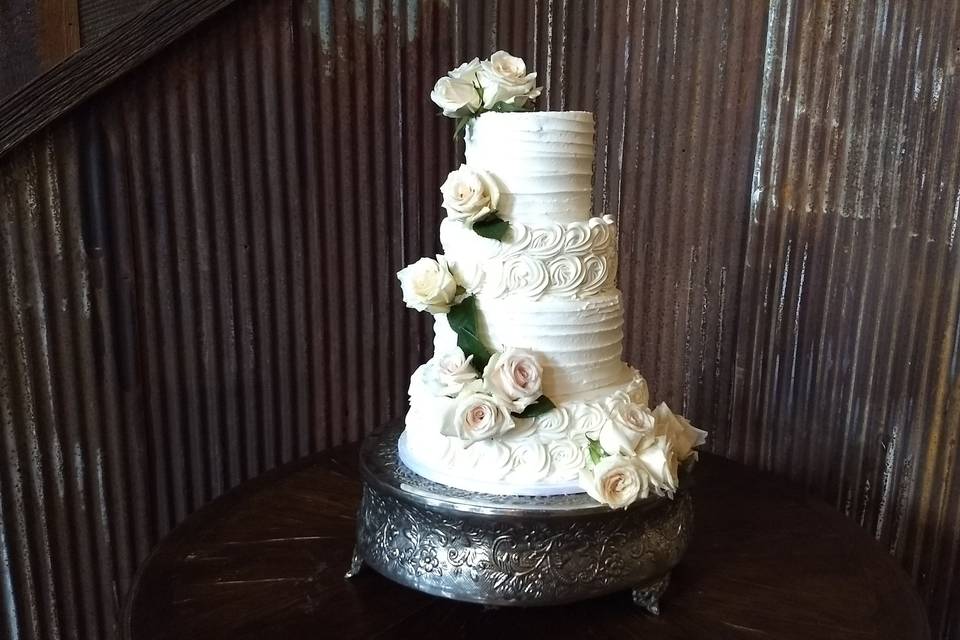 White wedding cake with white flower decorations