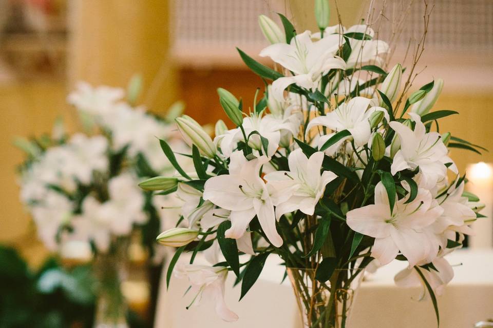 White oriental lilies with gold birch branches and gold wire provide an elegance to the altar. Photo by Shane Godfrey Photography.