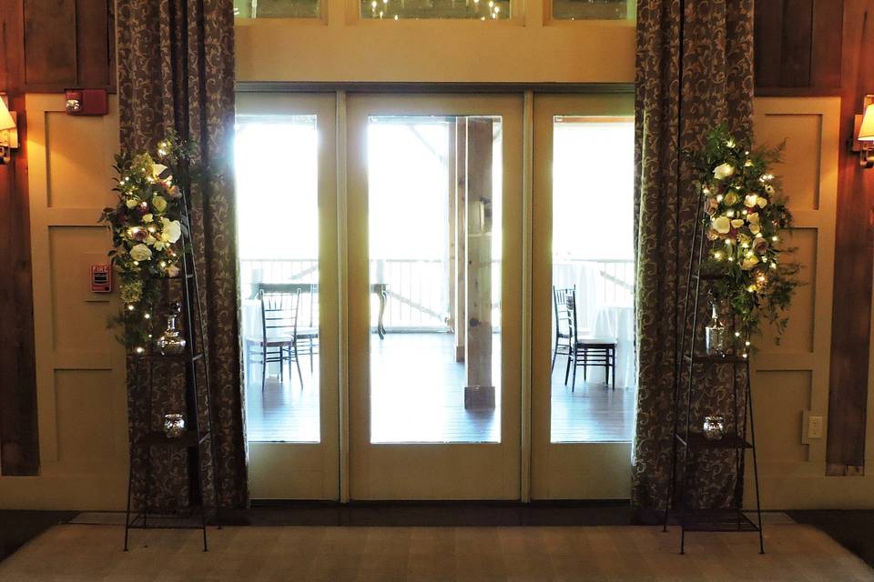 Towers adorned with flowers and fairy lights frame the ceremony space at Gibbet Hill.