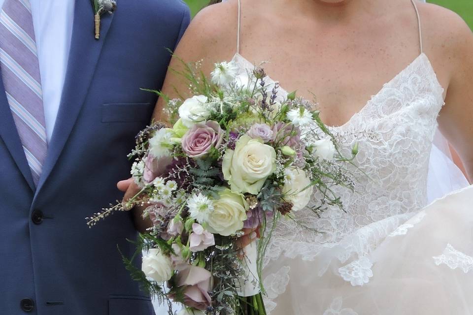 Cascade bouquet in shades of purple and ivory. Touches of limonium, lavender and nigella add to its romantic nature.