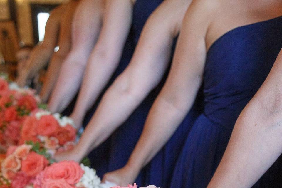 Bridesmaid bouquets using coral roses and mixed flowers and greeneryFlowers by Exotica the signature of flowers Photos by C. Baron PhotographyVenue at Crystal Springs