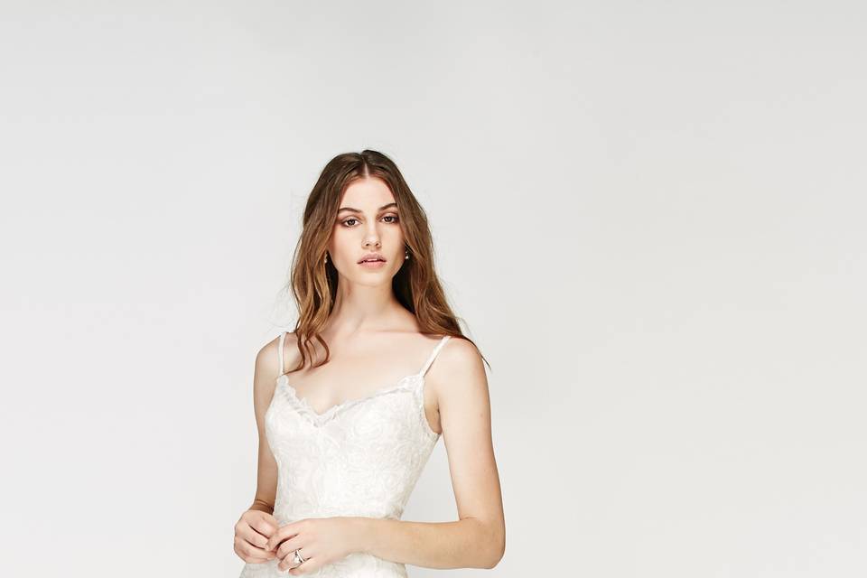 56309 Moravia Crop Top <br> Ready to break from tradition? Our designers created this top in our bridal collection for the bride who isn’t afraid to have a little fun. This ivory cropped top with a halter neckline is lined with stretch satin. The high neckline is a lovely complement to the shorter crop, giving you a look that’s modern but still polished. And as a nod to the classic wedding look, it’s finished with pearl buttons. For the bride thinking about a quick change after the ceremony, this top can be paired with a ball gown skirt for the chapel and a beaded cocktail skirt for the party.
