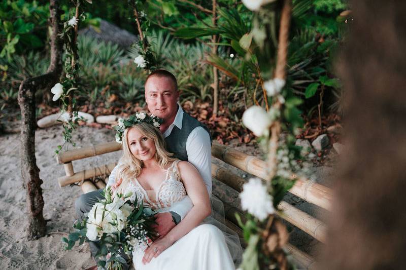 The bride and the groom during their wedding on a swing