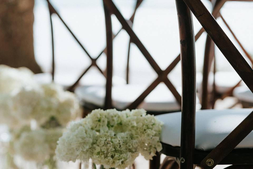 Ceremony chair decor details with white flowers inside a vase