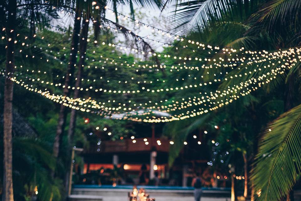 Beautiful wedding table on the beach with luminaries, greenery, flowers and candles