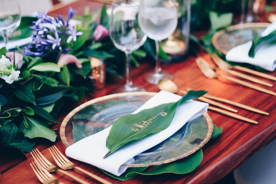 Wedding table details with glass plate, leaf and greenery