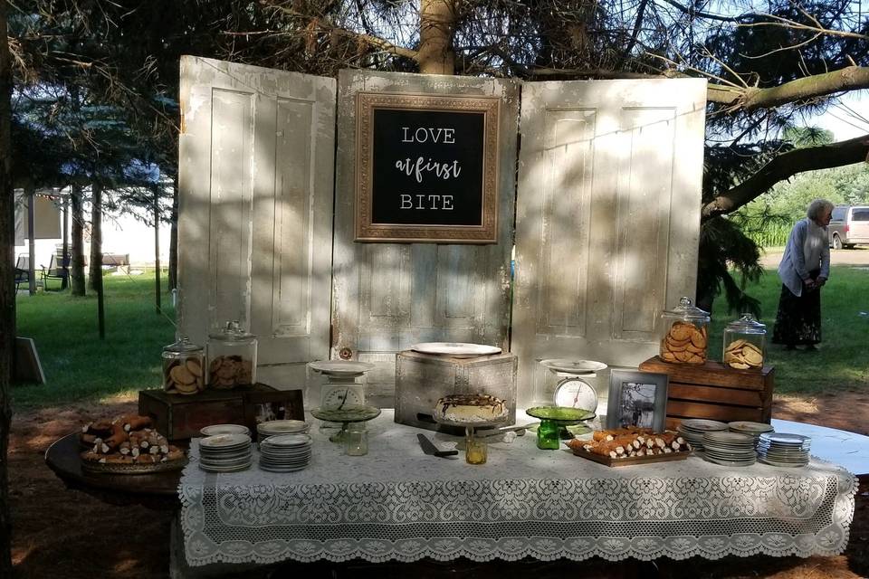 Dessert table being setup for vintage woodland backyard wedding in 6/23/18