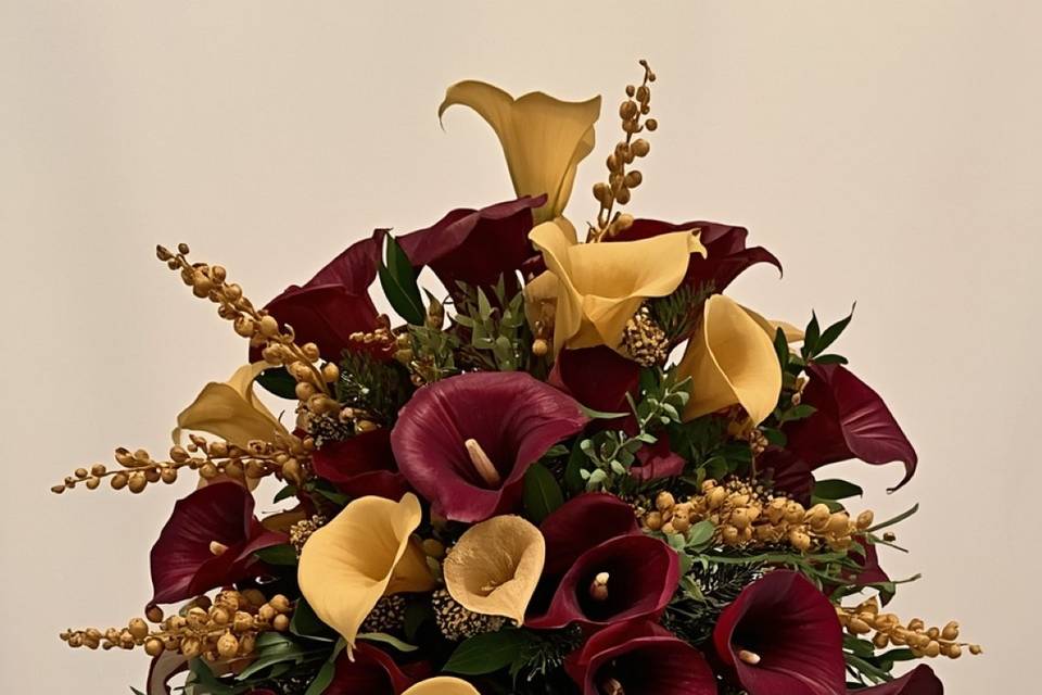 Tall elegant table centerpiece with purple calla lilies and gold calla lilies, dark brown greenery, and gold berry clusters, arr.jpg