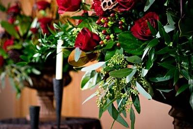 Red roses, berries, cymbidium orchids, fern curls, and lotus pods