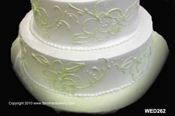Wedding cake with light green piping and flowers