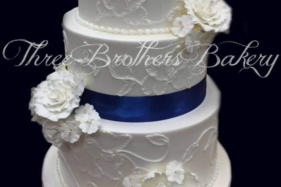 White wedding cake with blue ribbon