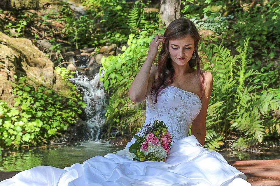 Bride sitting on bridge