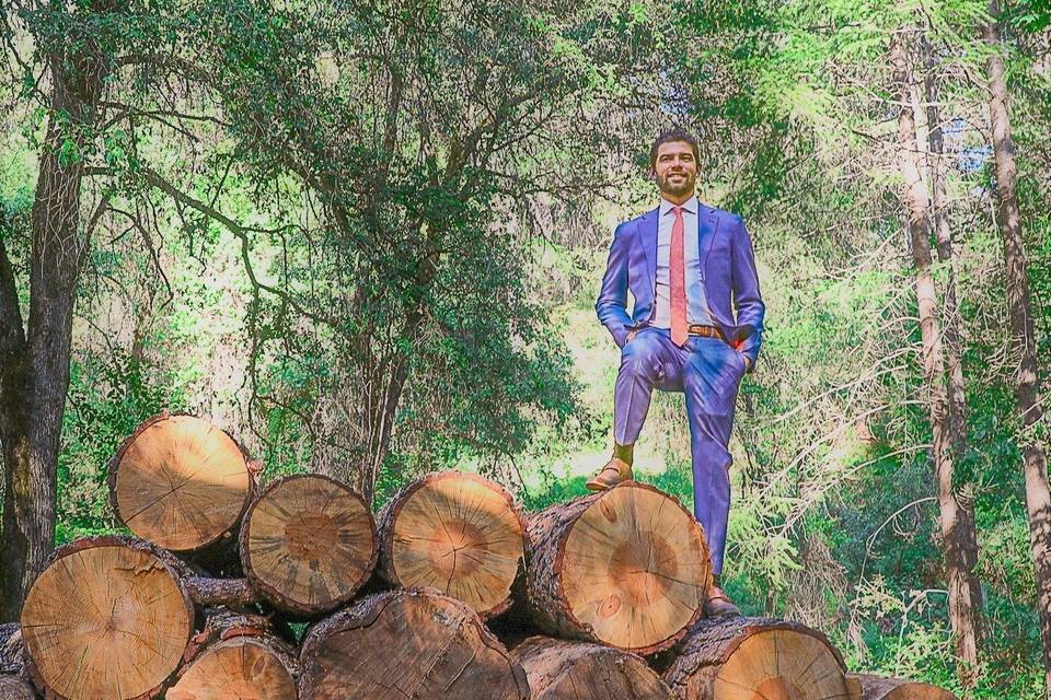 Groom standing on stack o logs