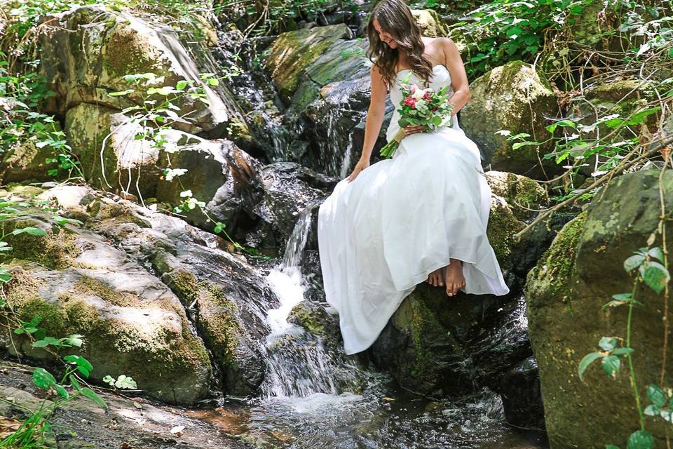 Bride sitting in waterfall