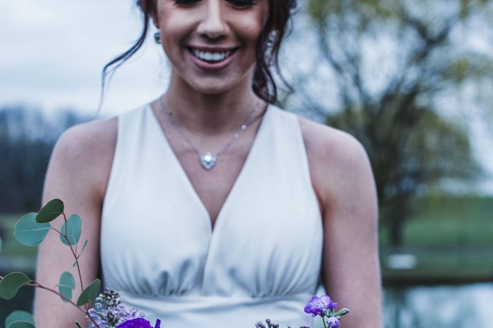 Sleeveless wedding gown and violet bouquet