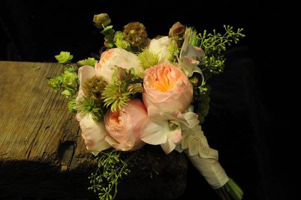 Peach-toned garden roses, scabiosa, and antique ribbon were orchestrated to create a vintage feel for this bridal bouquet.